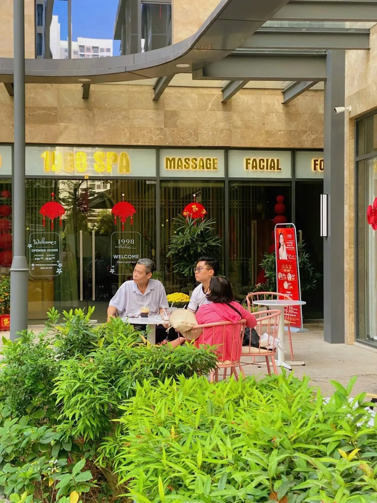 Ba khách ngồi bàn ngoài trời trước The Hoa Grand Park